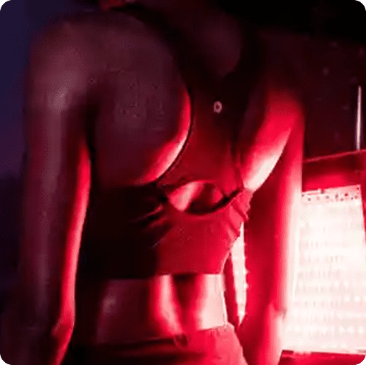 A woman in red bra and panties standing next to window.