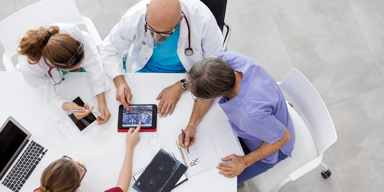 A group of doctors sitting around a table.